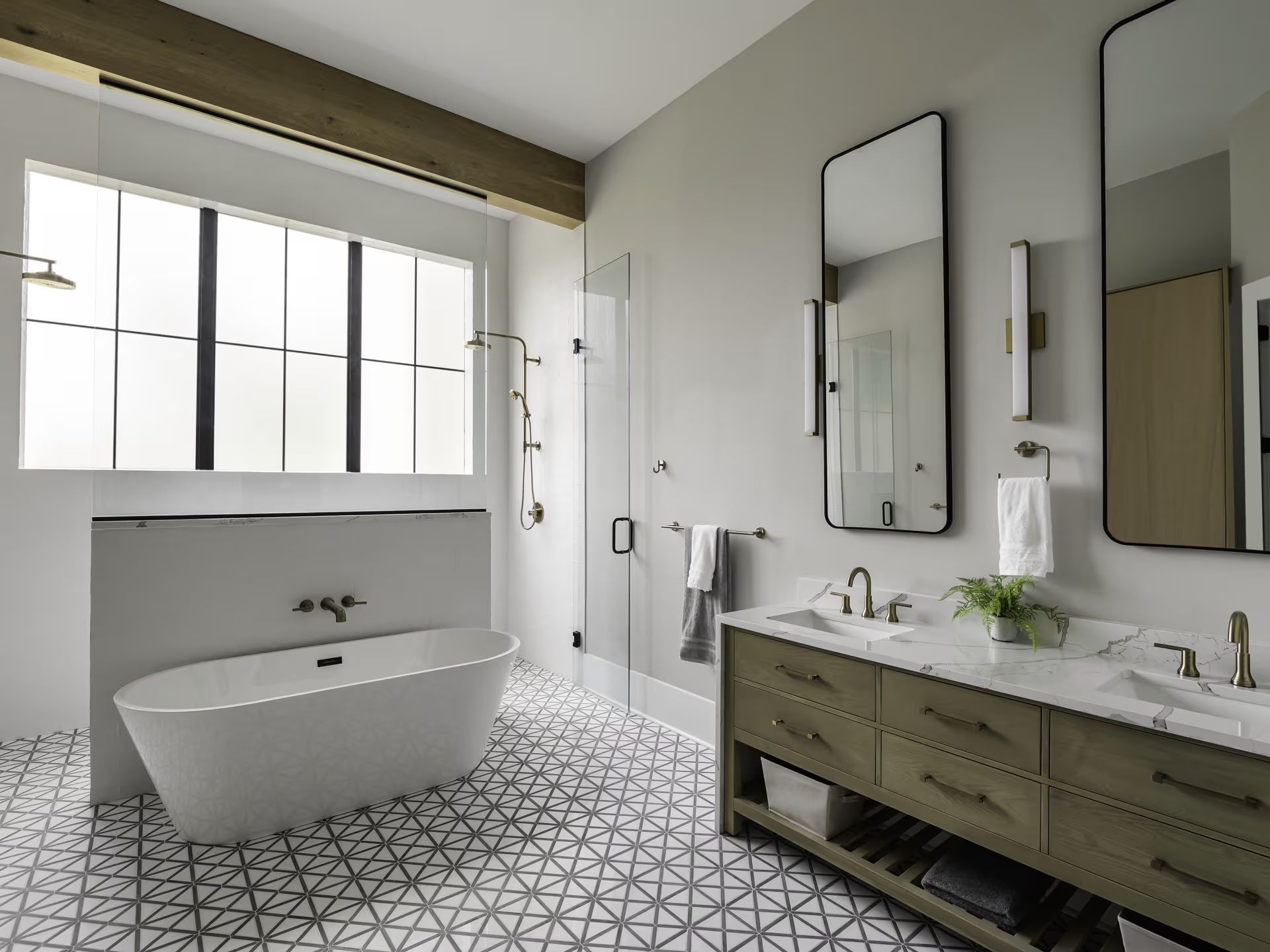 A bathroom with a bathtub , sinks , mirrors and a window.