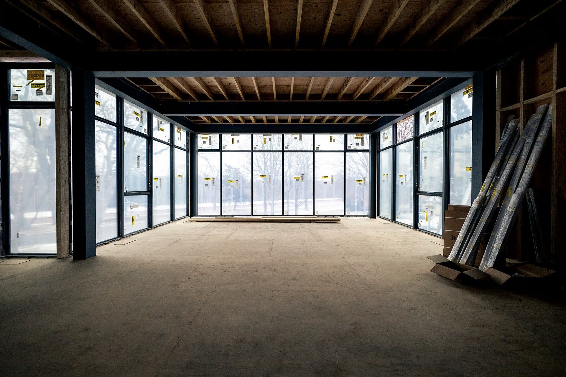 An empty room with a lot of windows and a wooden ceiling