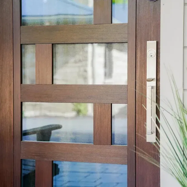 A close up of a wooden door with glass panels