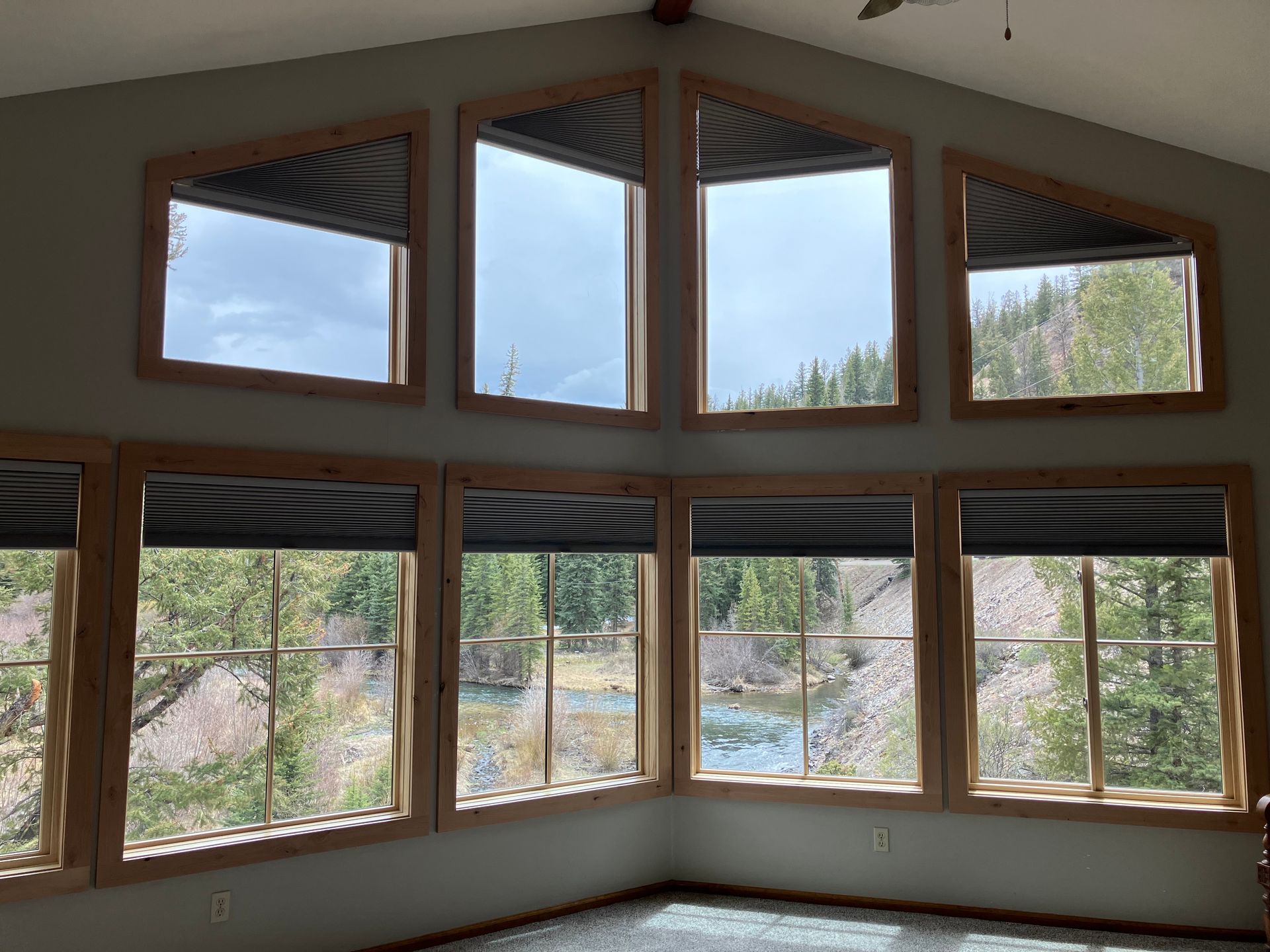 A living room with a lot of windows and a view of a river.