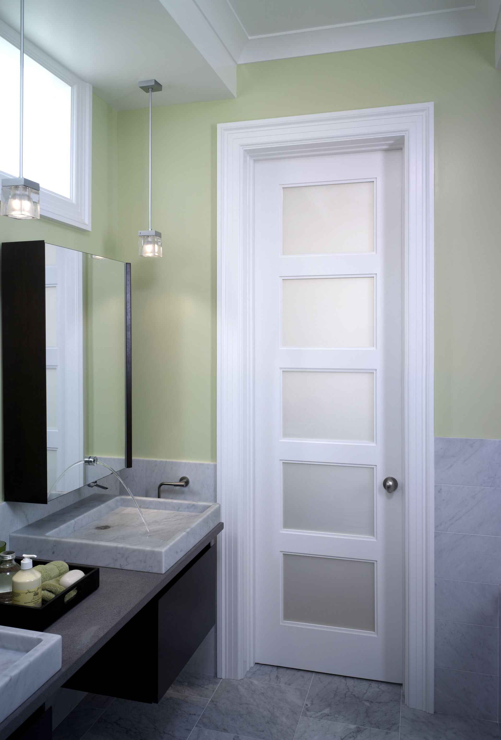 A bathroom with a white door and a sink