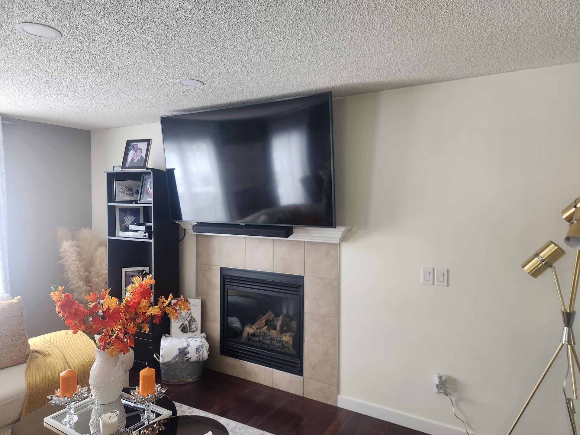 A living room with a fireplace and a flat screen tv mounted on the wall.