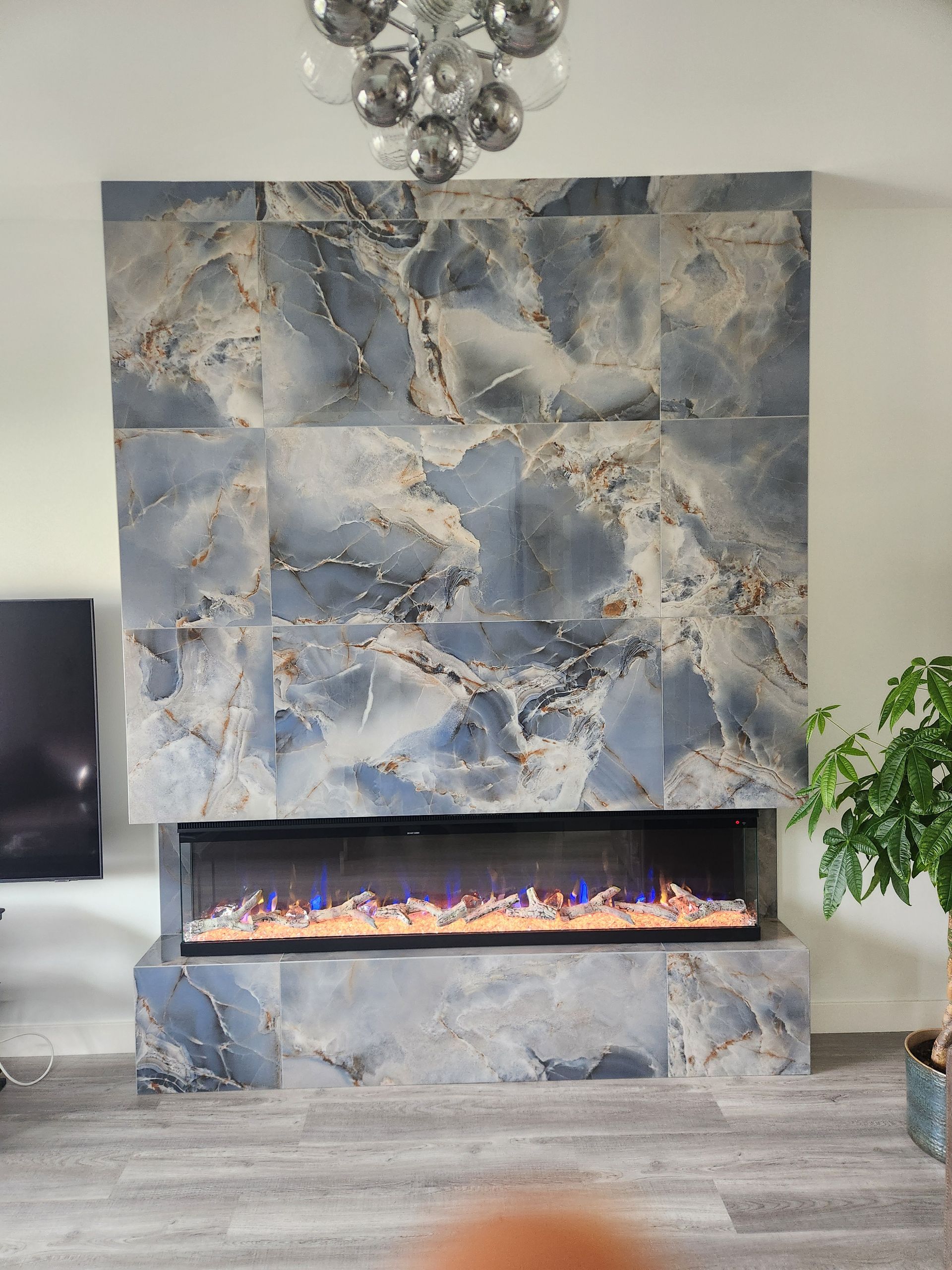 A living room with a fireplace and a television.