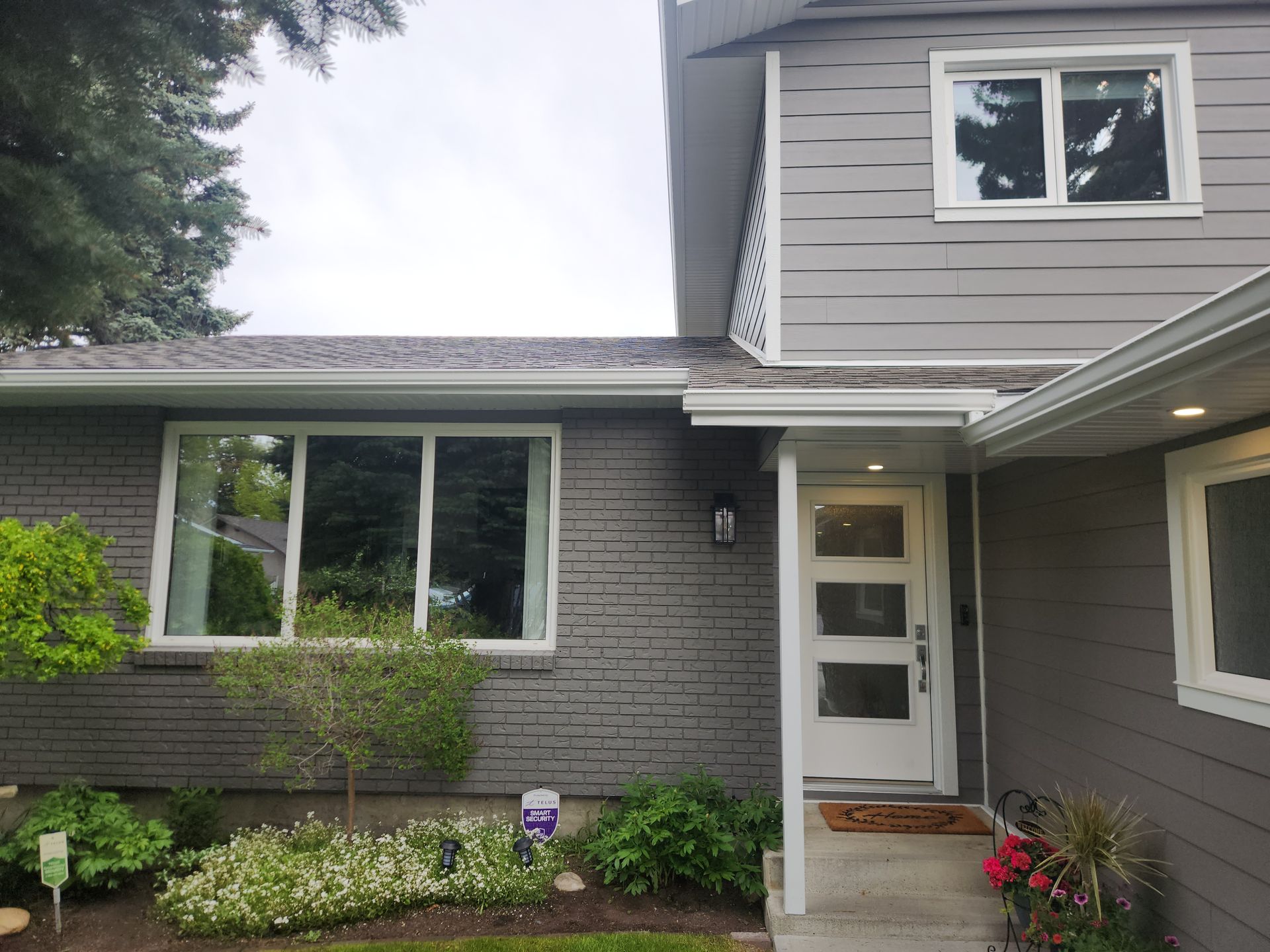 The front of a brick house with a white door and windows