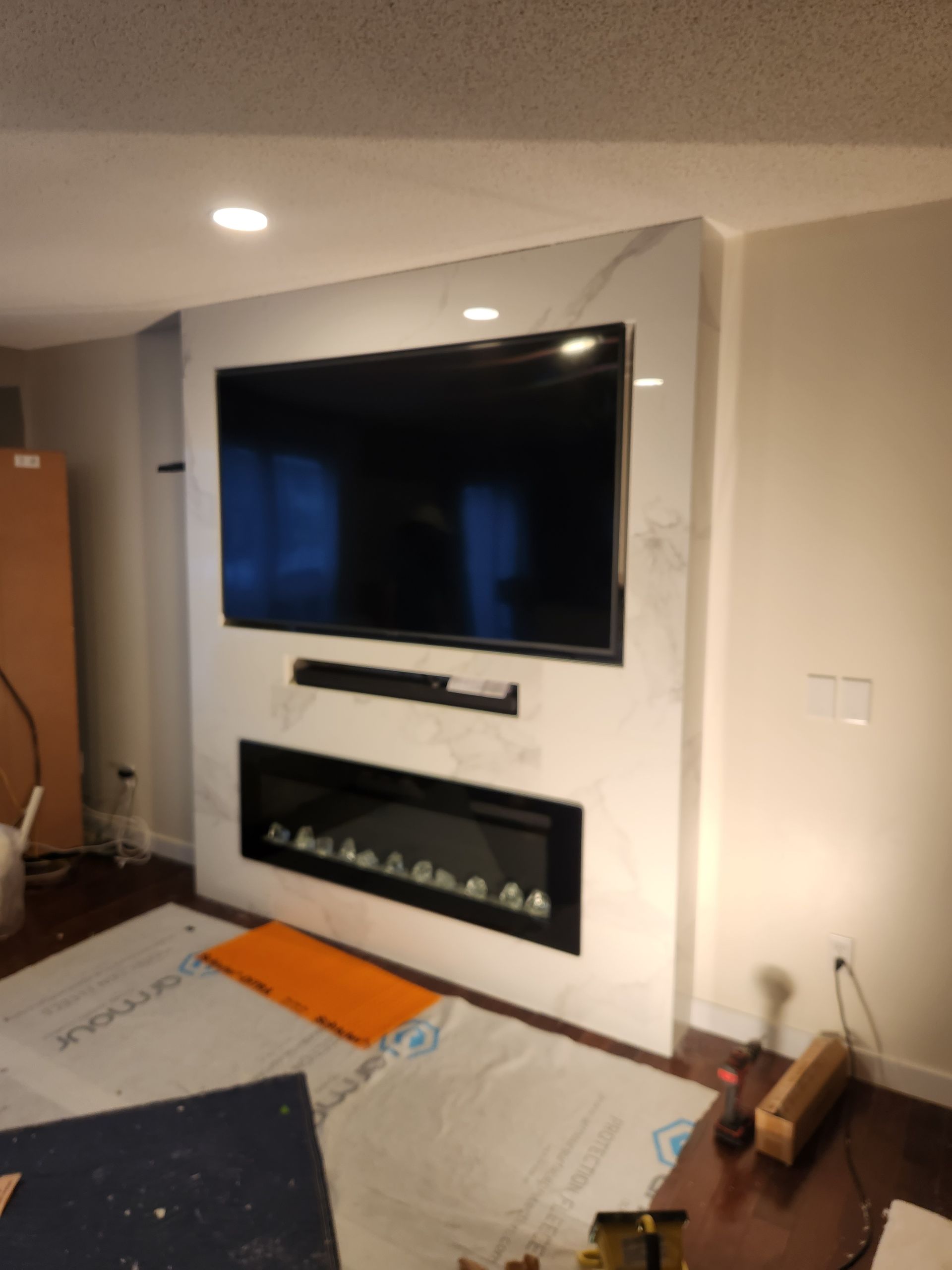 A living room with a fireplace and a flat screen tv
