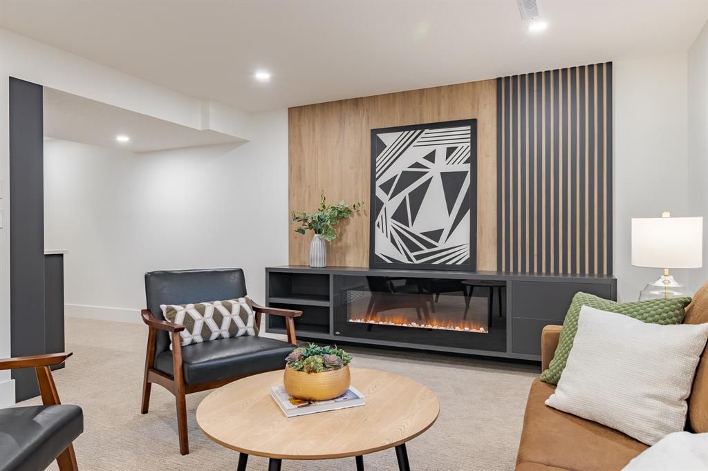 A living room with a couch , chair , coffee table and fireplace.