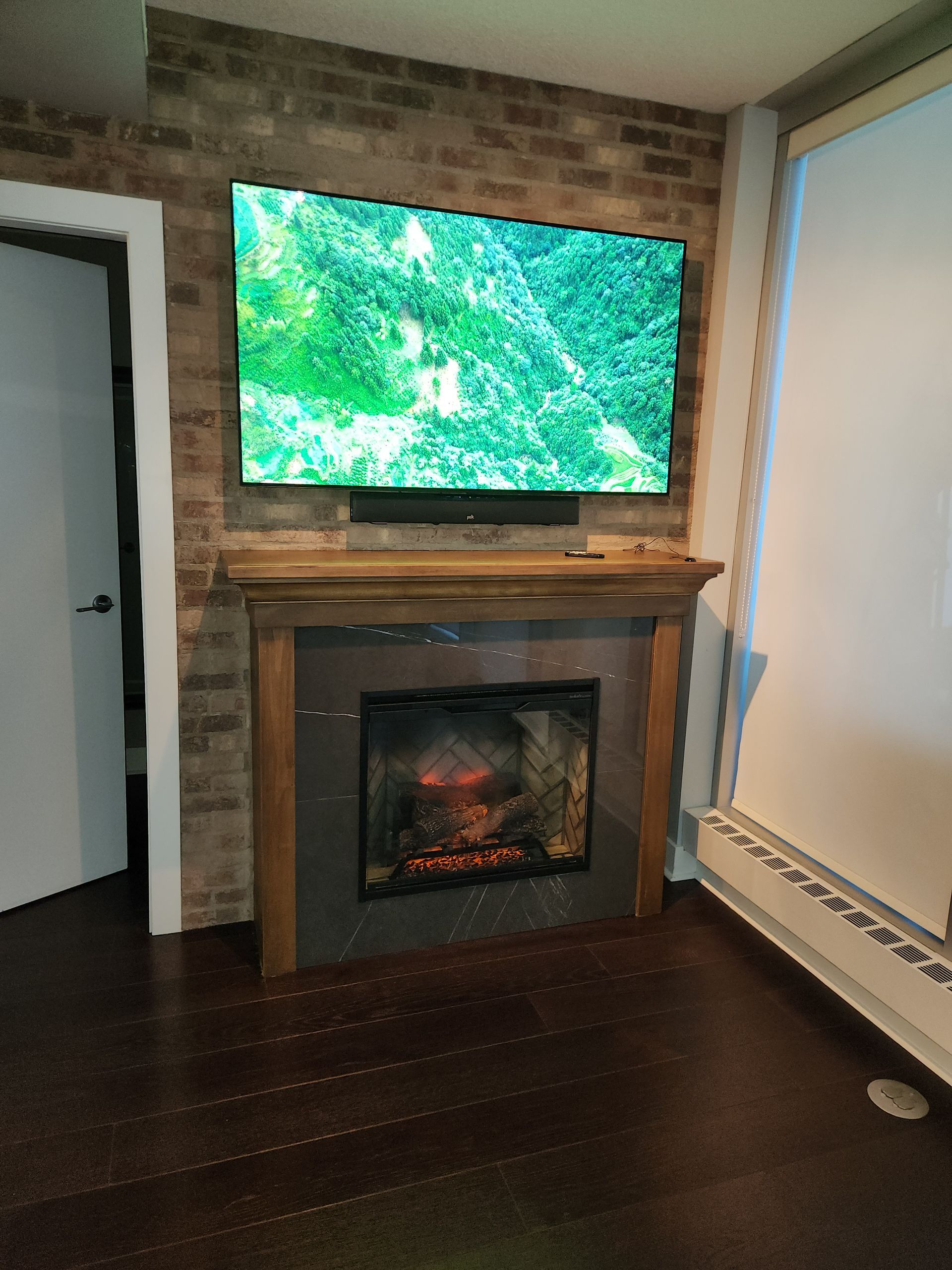 A living room with a fireplace and a flat screen tv