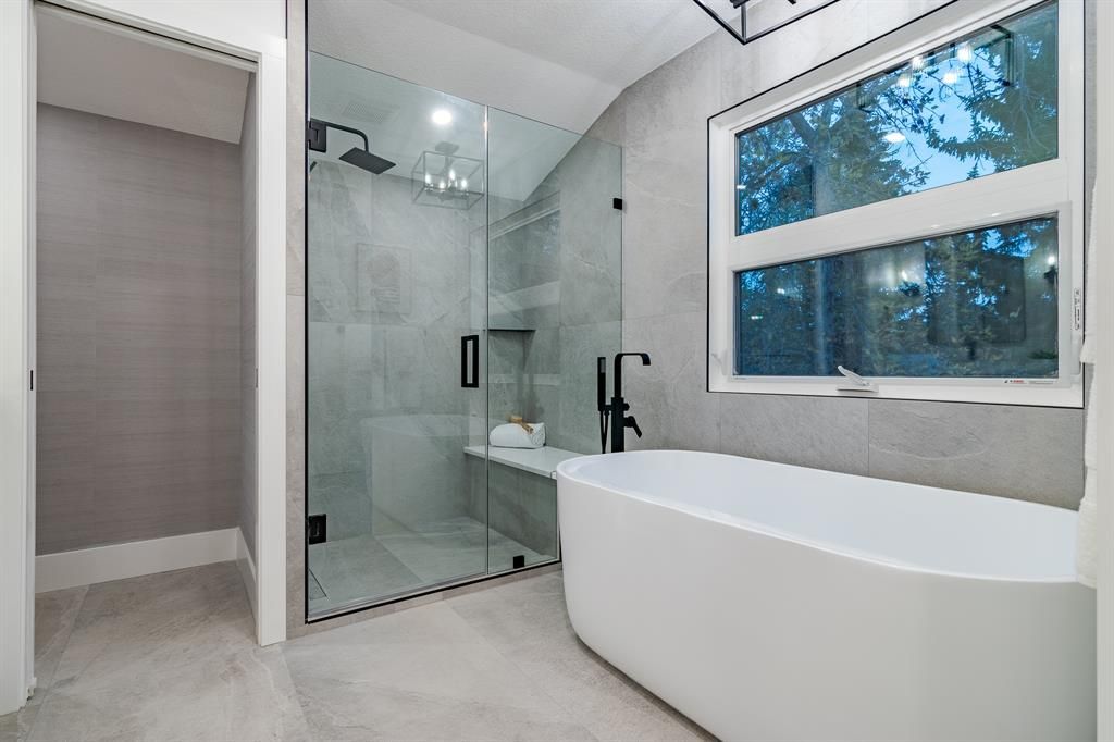 A bathroom with a tub , shower , and window.