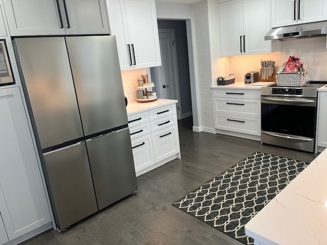A kitchen with stainless steel appliances and white cabinets.