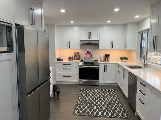 A kitchen with white cabinets and stainless steel appliances