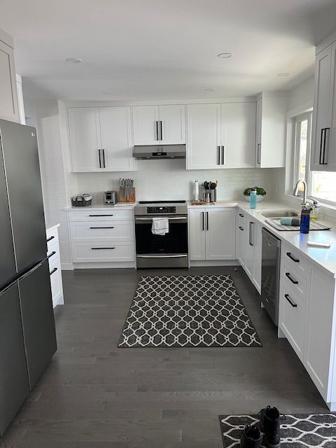 A kitchen with white cabinets and stainless steel appliances