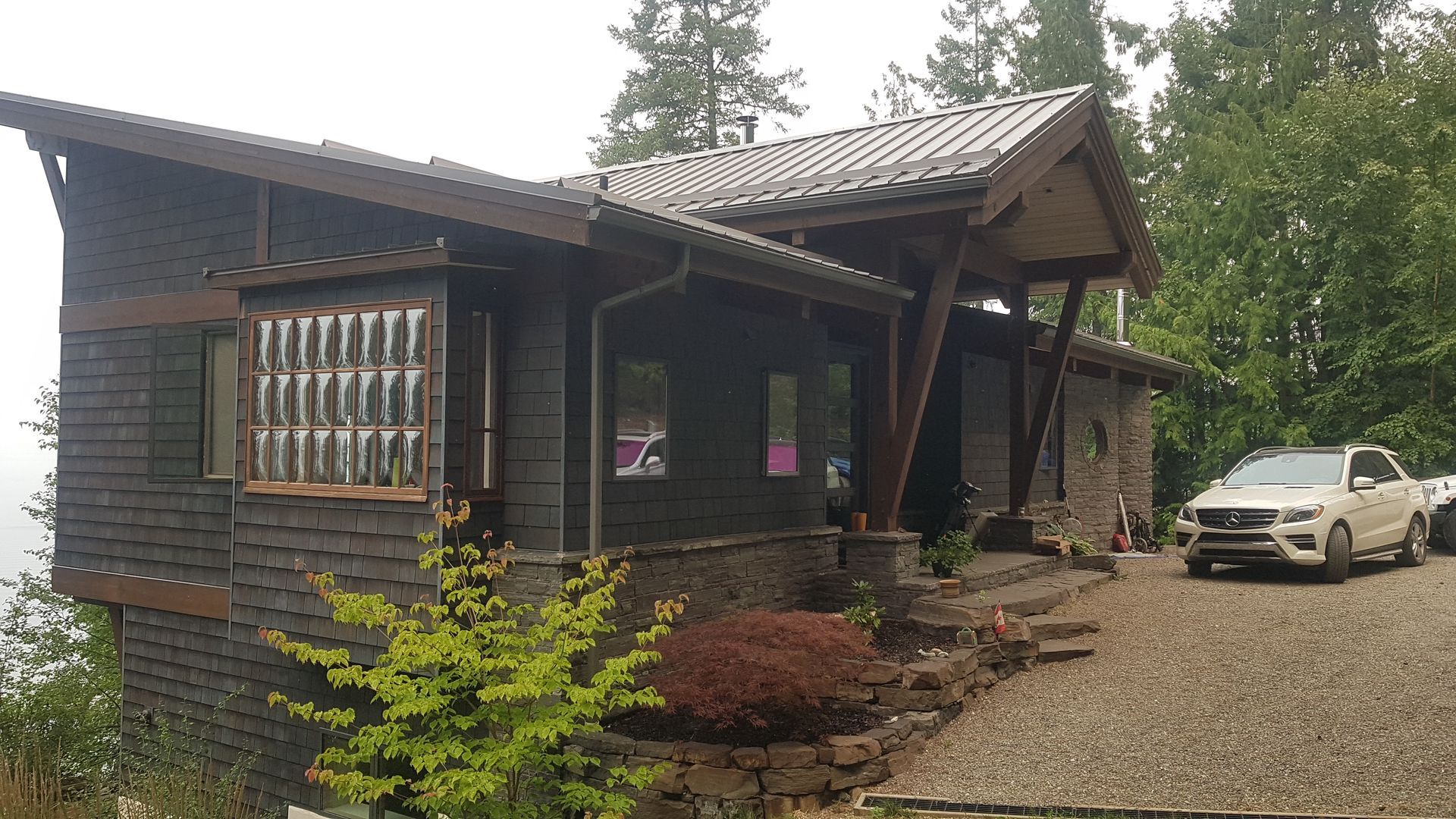 A car is parked in front of a small house.