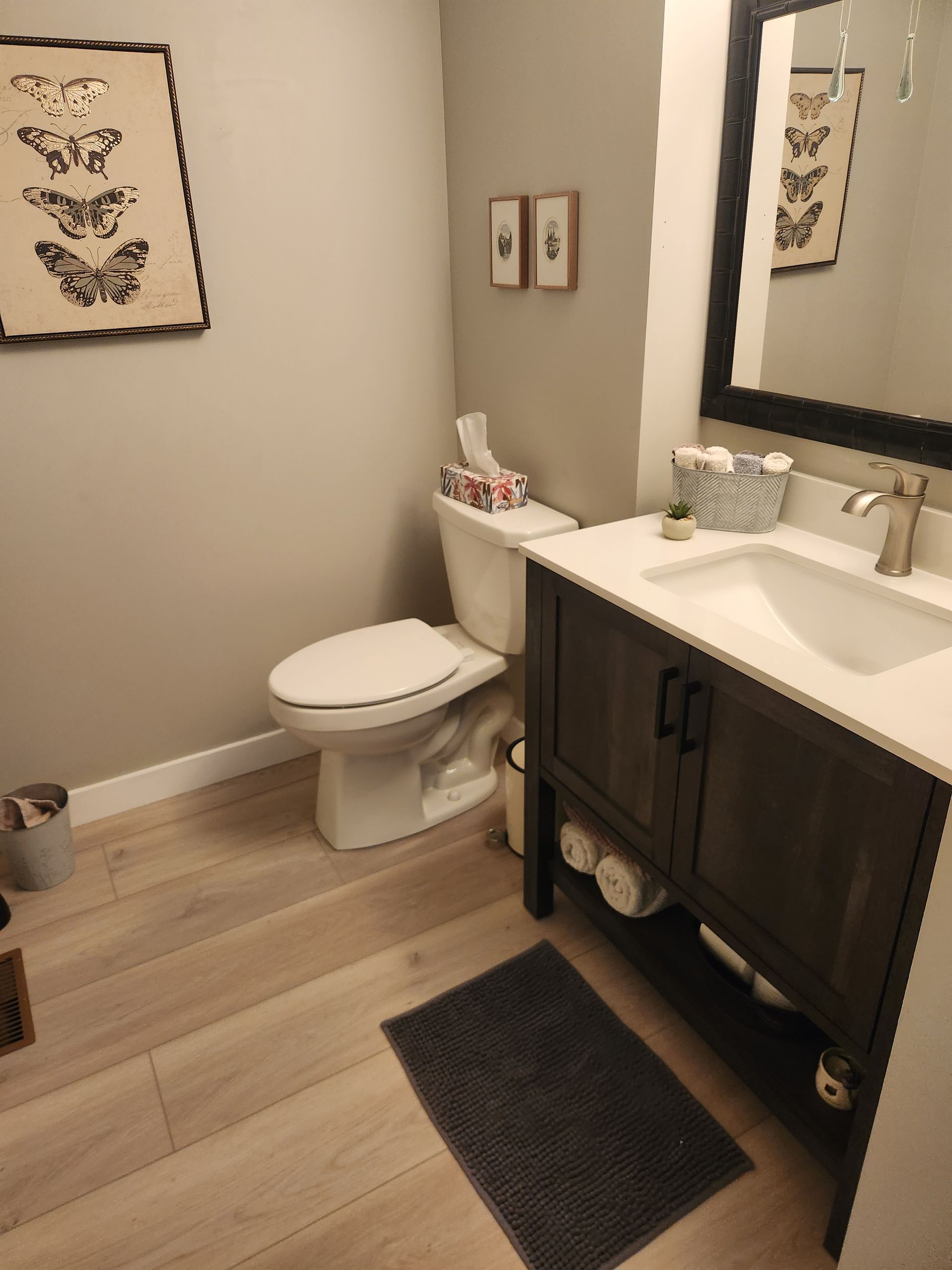 A bathroom with a toilet , sink and mirror