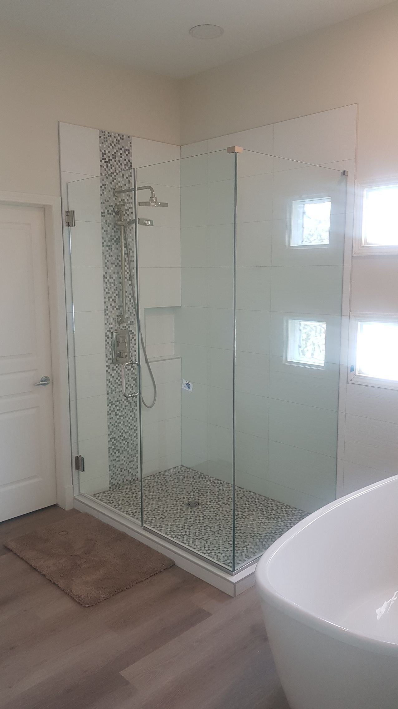 A bathroom with a walk in shower and a bathtub.