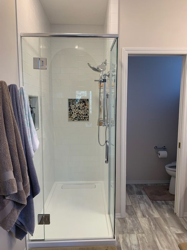 A bathroom with a walk in shower and a toilet.