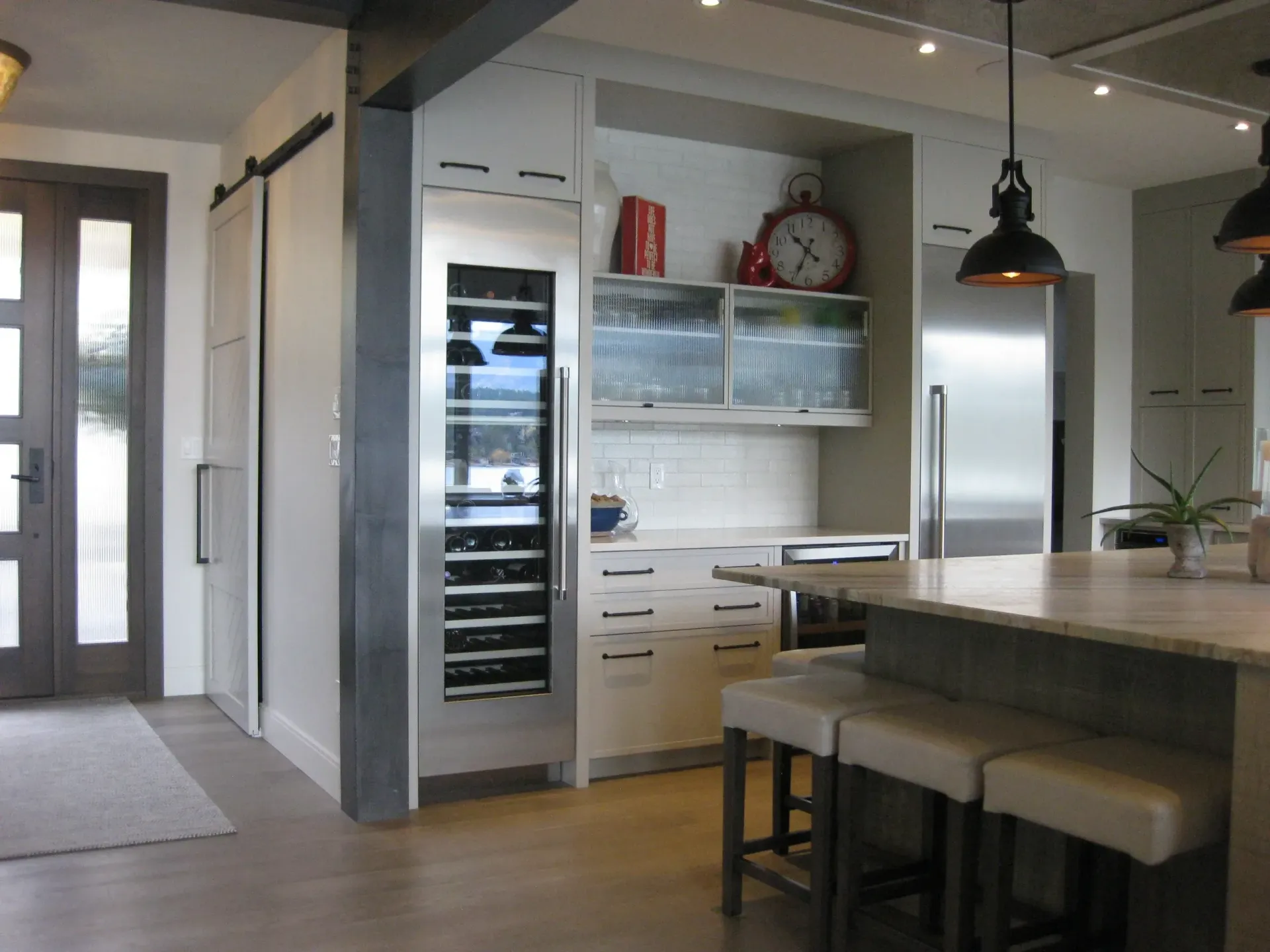 A kitchen with stools and a clock on the wall