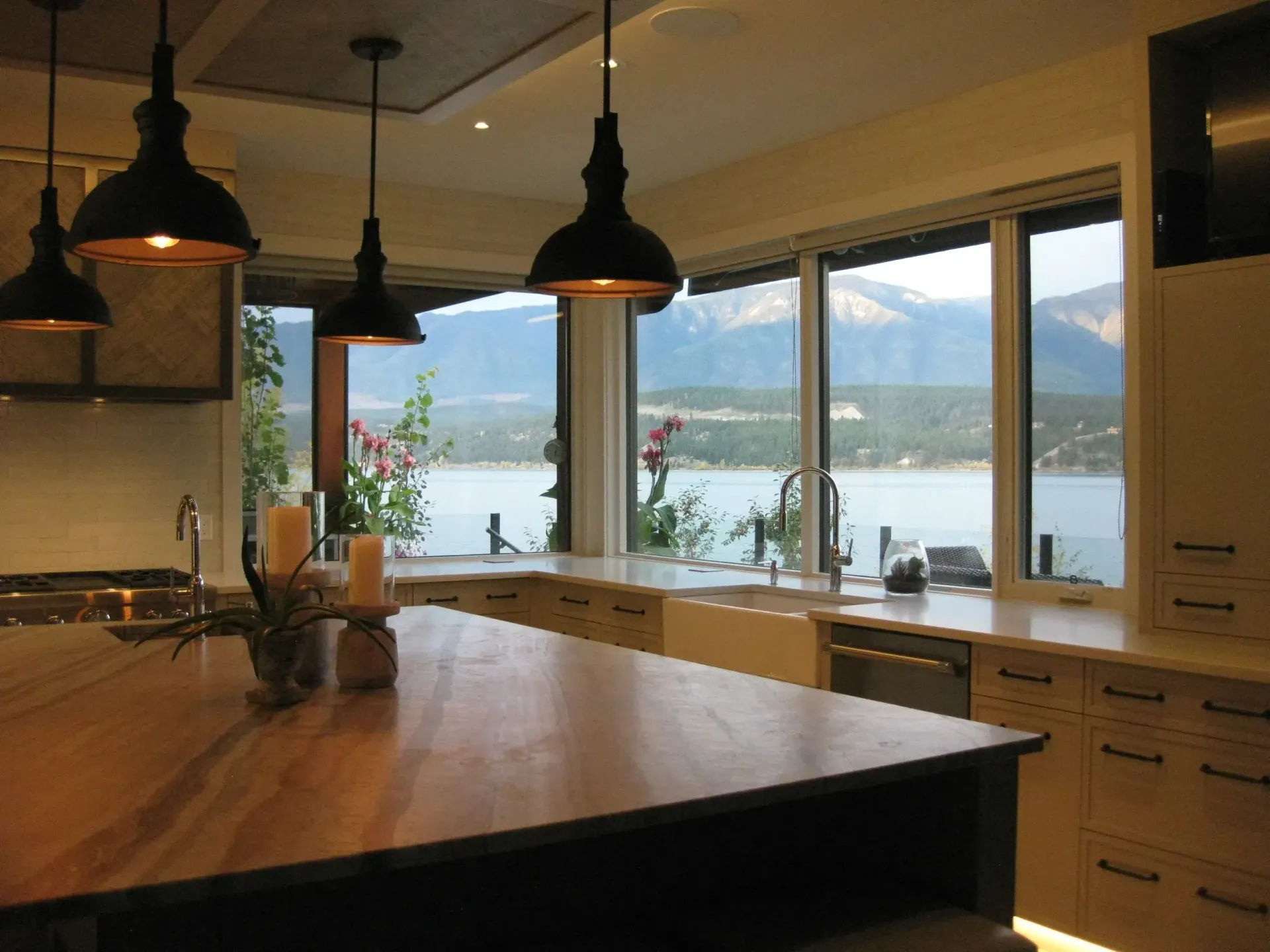 A kitchen with a view of a lake and mountains