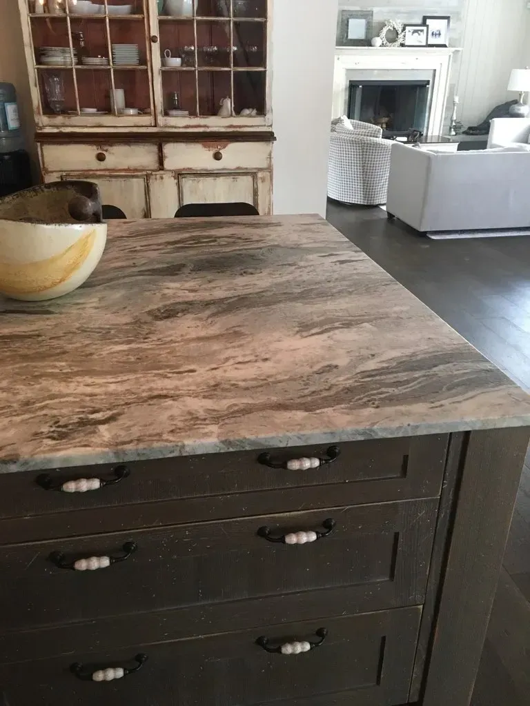 A marble counter top with a bowl on it in a living room.