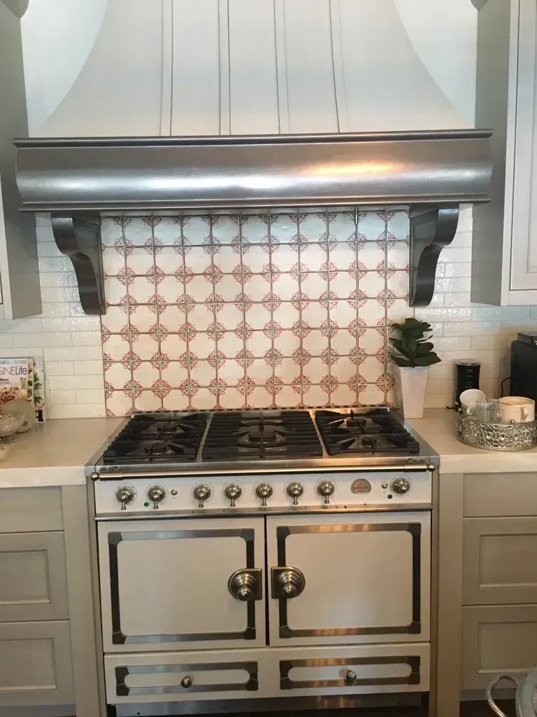 A kitchen with a stove and a hood above it