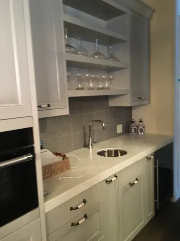 A kitchen with white cabinets and a sink