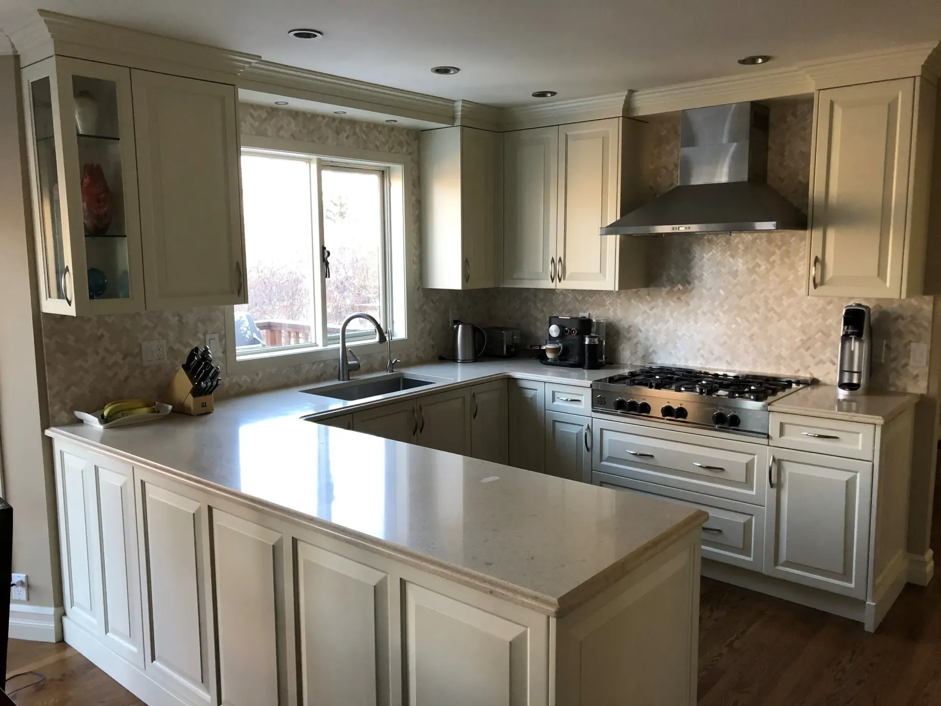 A kitchen with white cabinets and a stove top oven