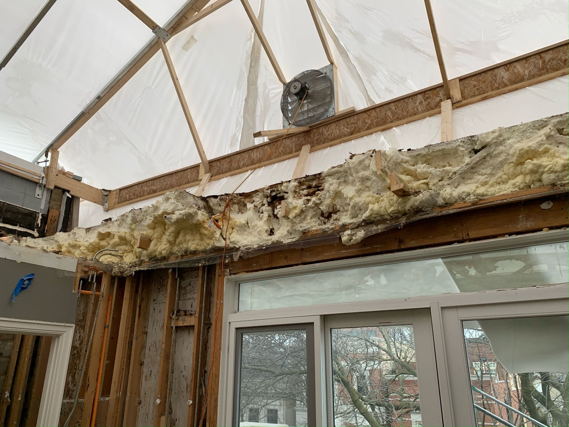 365 Construction Tent with exhaust fan installed above spray foam clad truss above french doors with transom