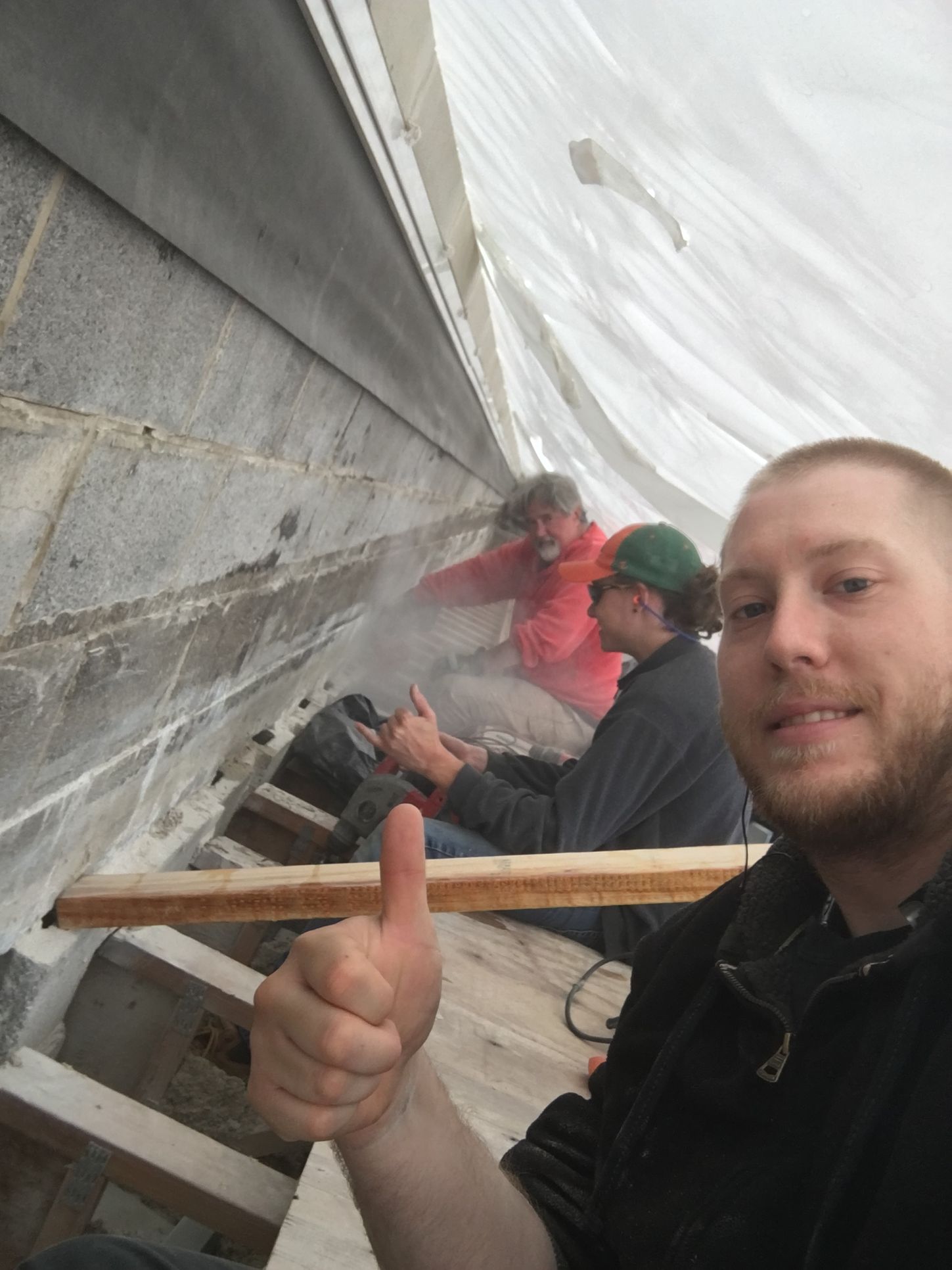 365 Construction Tent's Perimeter Tent installed with 3 crew members removing mortar from trusses embedded in masonry wall