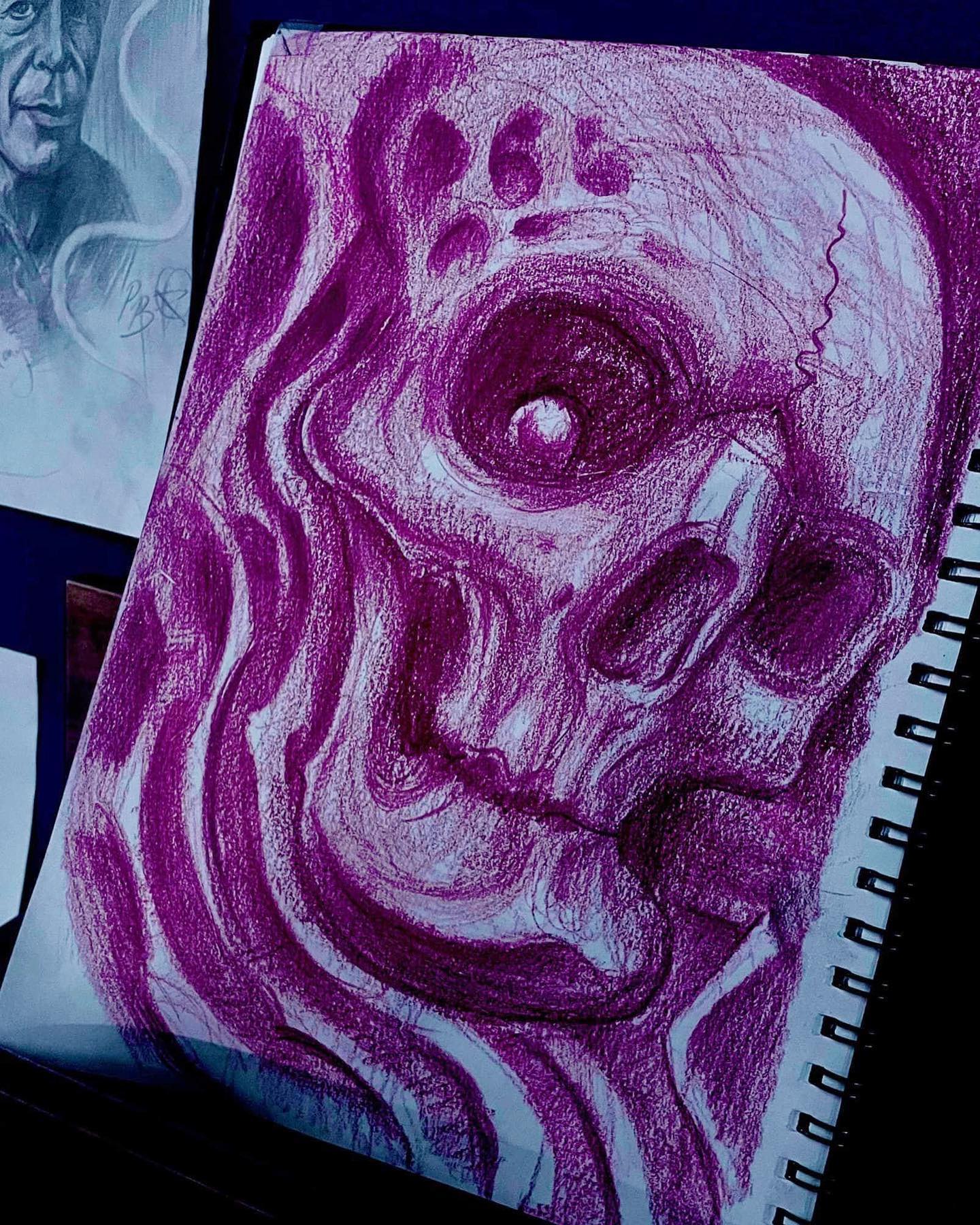 A spiral notebook with a drawing of a skull on it