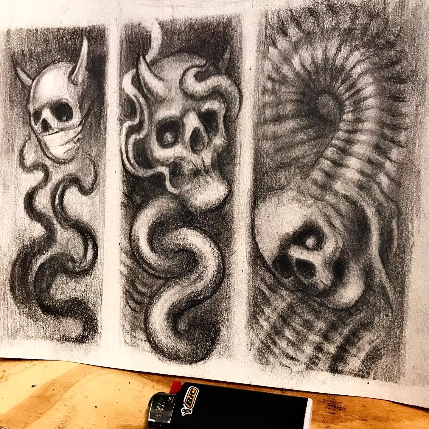 A drawing of skulls and snakes next to a lighter
