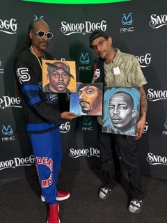 Snoop dogg and two other men holding paintings of snoop dogg