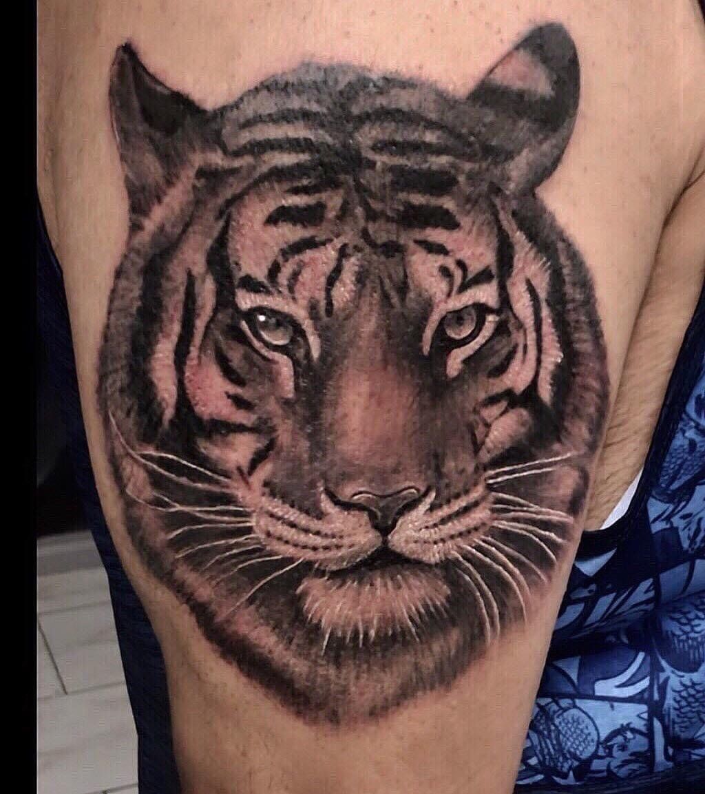 A man has a tattoo of a tiger on his arm