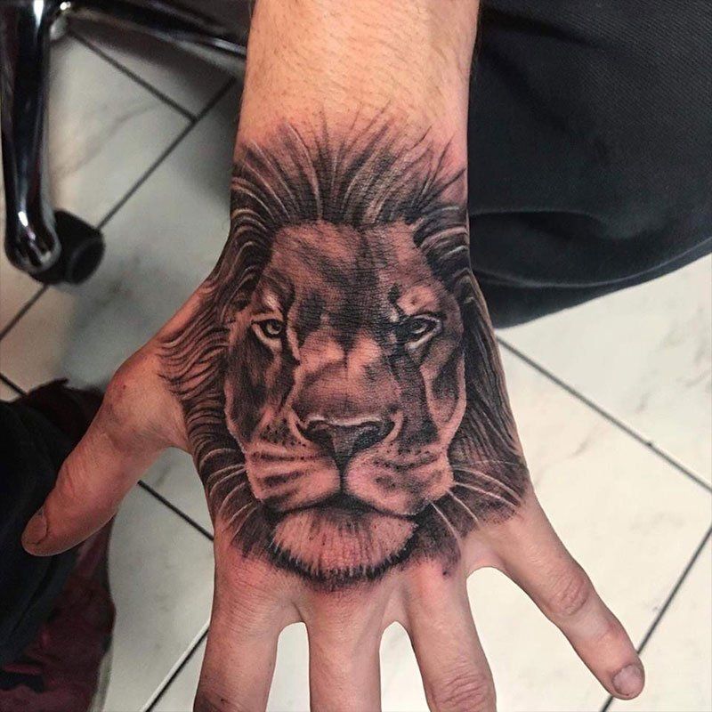 A man has a tattoo of a lion on his hand