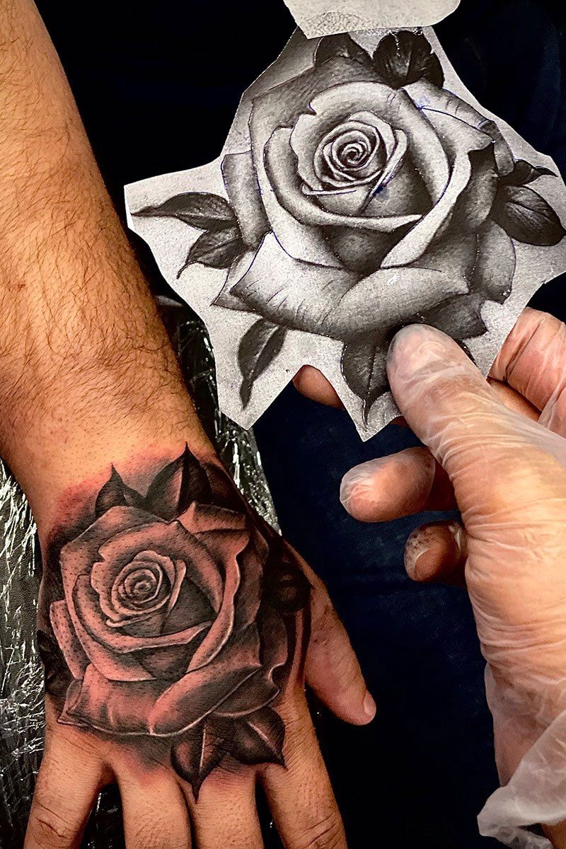 A person has a tattoo of two roses on their wrist