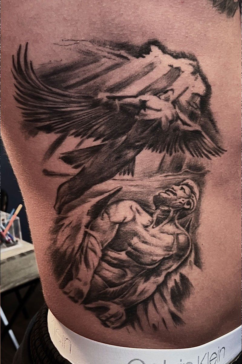 A man has a tattoo on his side of a man and a bird