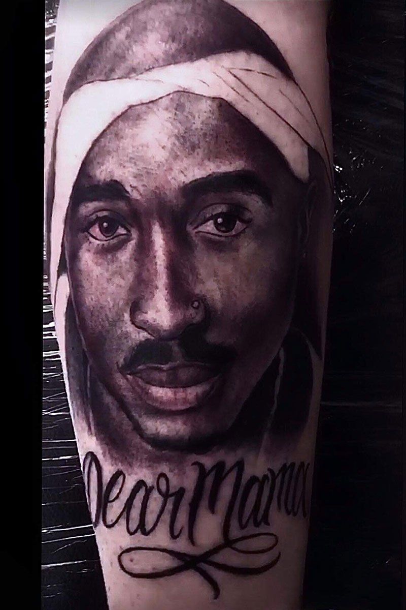 A tattoo of tupac shakur on a person 's arm