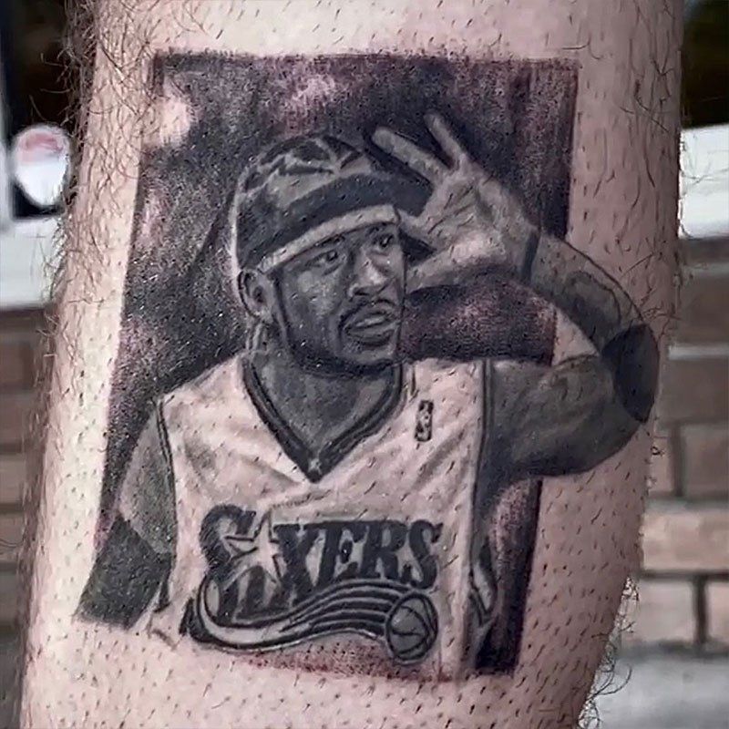 A man has a tattoo of a basketball player on his leg.