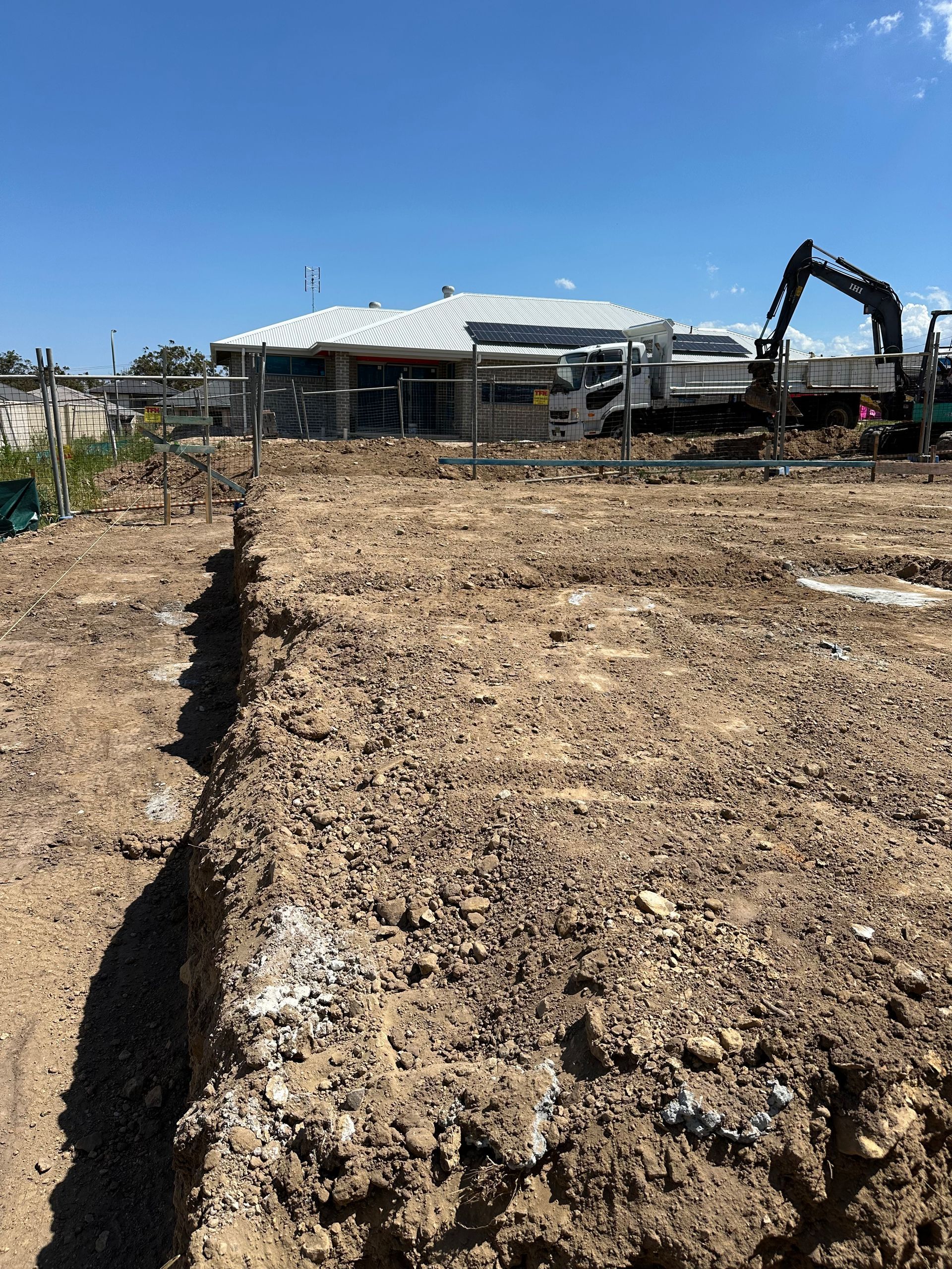 A large pile of dirt is sitting in front of a house under construction.