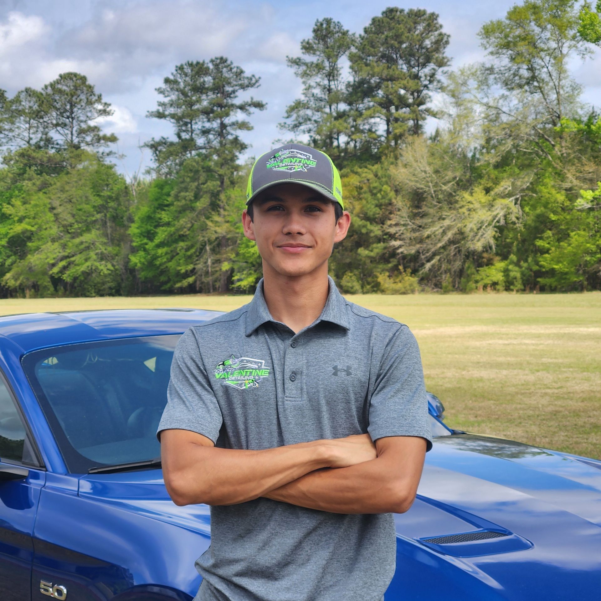 A Person in a Black Jumpsuit Washes a White Car Covered in Soap — Valentine Detailing LLC in Walterboro, SC