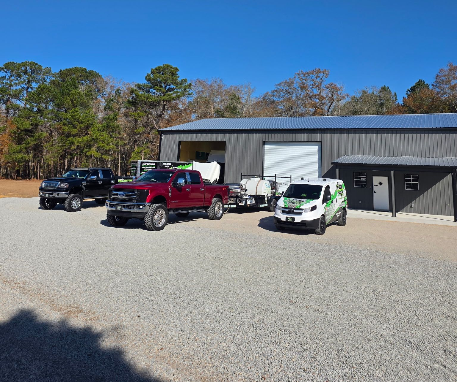 A Red Pickup Truck, Black Truck, and Work Van Parked in Front of Building — Valentine Detailing LLC in Walterboro, SC