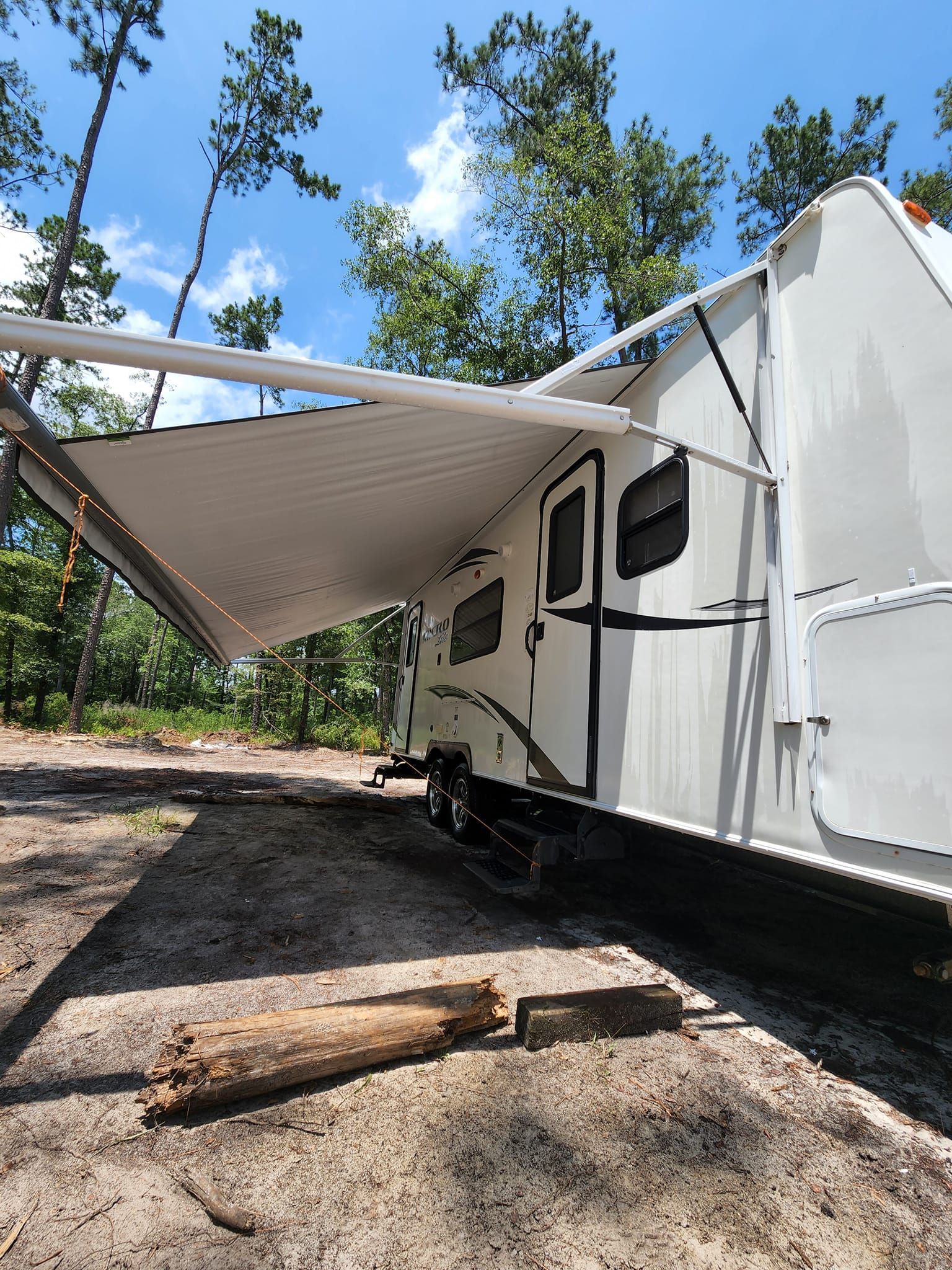 A White Travel Trailer Parked in a Wooded Area — Valentine Detailing LLC in Walterboro, SC