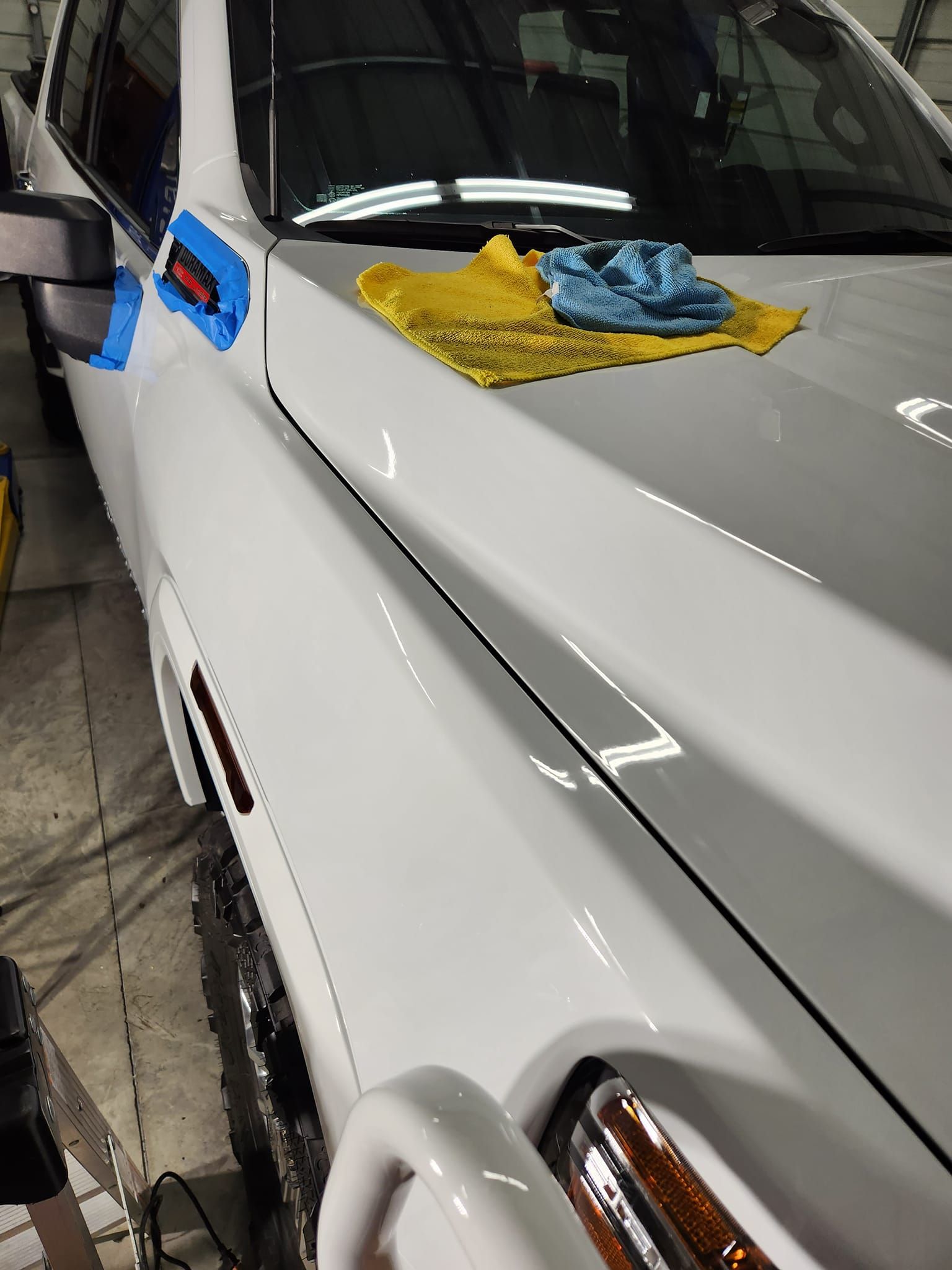 A White Vehicle Hood With Blue Painter’s Tape on the Fender — Valentine Detailing LLC in Walterboro, SC