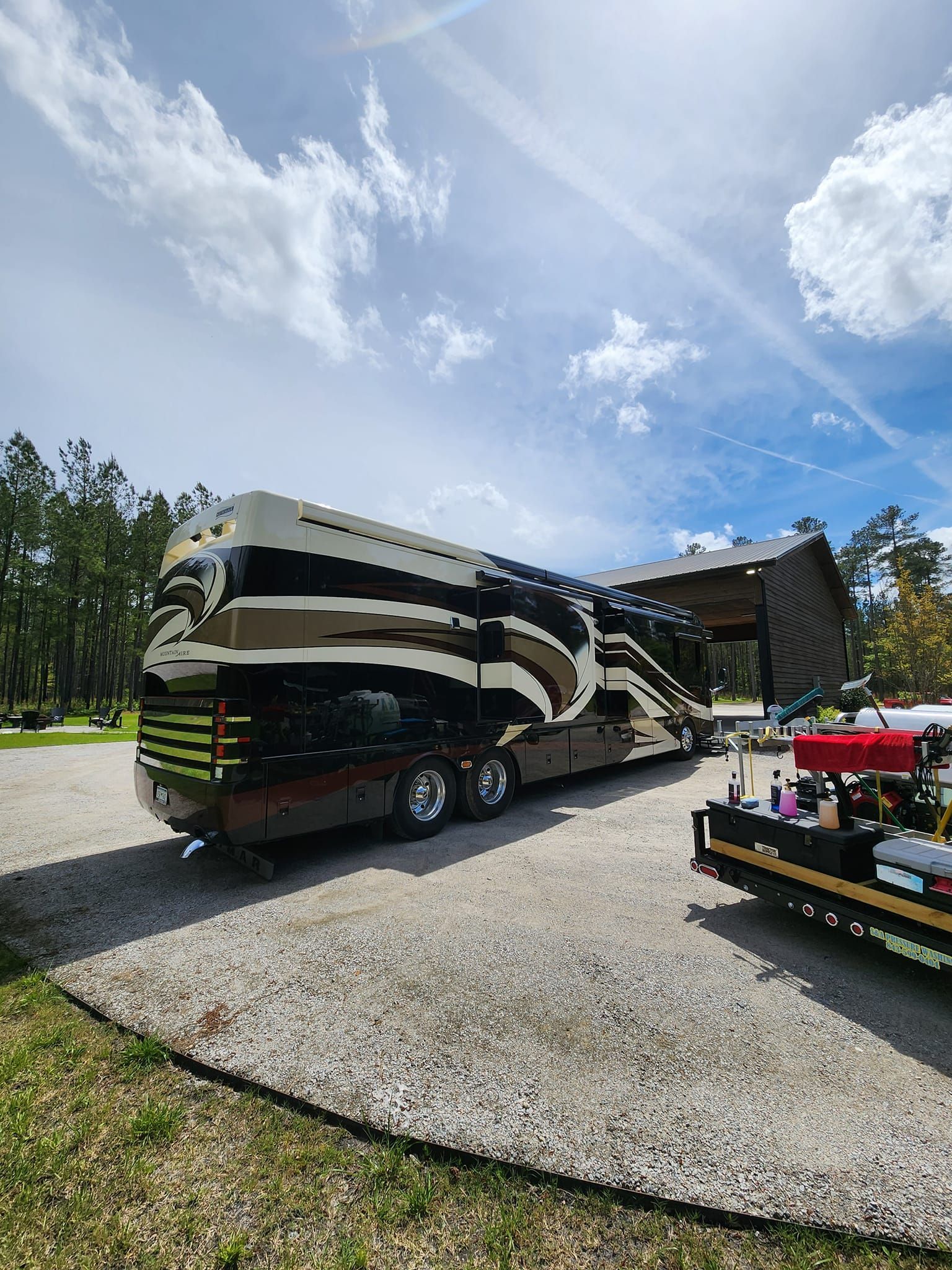 A Large, Black and Tan Luxury Motorhome Parked on a Gravel Lot — Valentine Detailing LLC in Walterboro, SC