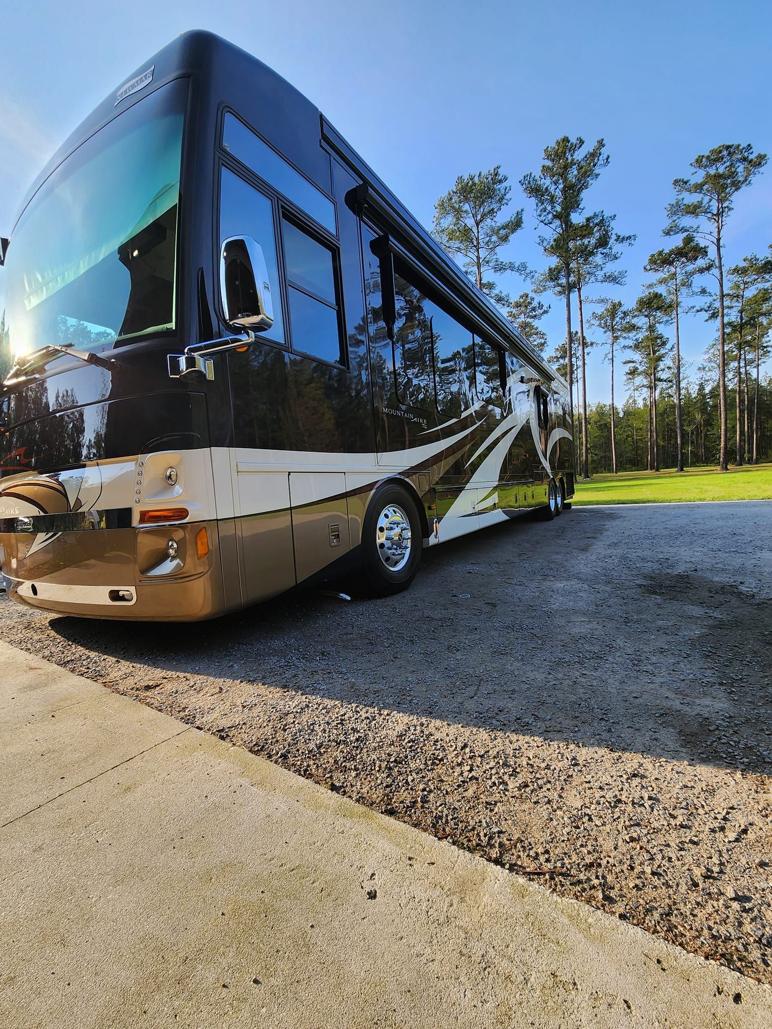 A Modern, Sleek Black and Gold Recreational Vehicle Parked on a Gravel Lot — Valentine Detailing LLC in Walterboro, SC