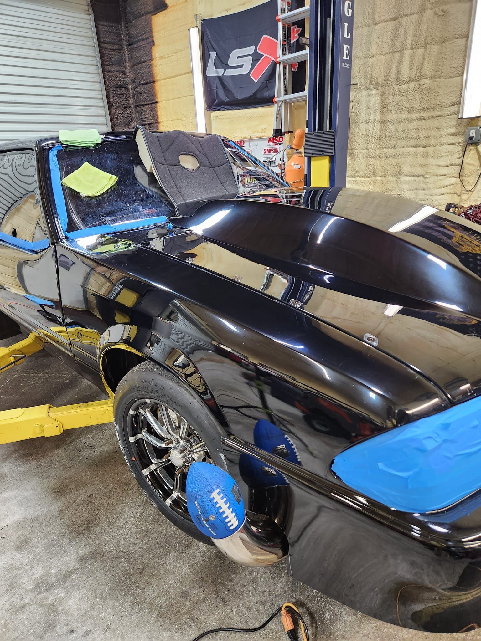 A Glossy Black Car With Blue Tape on Its Hood and Fender — Valentine Detailing LLC in Walterboro, SC