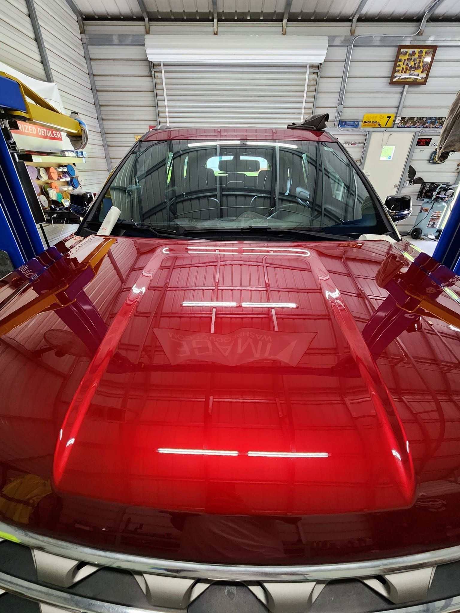 Close-up of a Glossy Red Vehicle Hood Inside a Workshop — Valentine Detailing LLC in Walterboro, SC