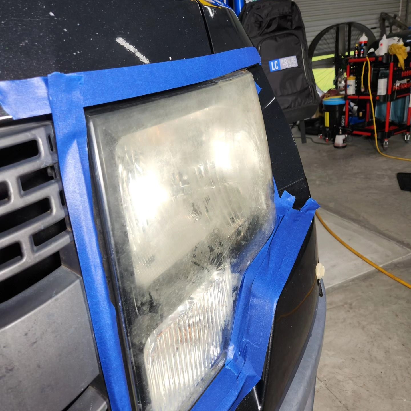 A Hazy Car Headlight Masked With Blue Painter's Tape — Valentine Detailing LLC in Walterboro, SC