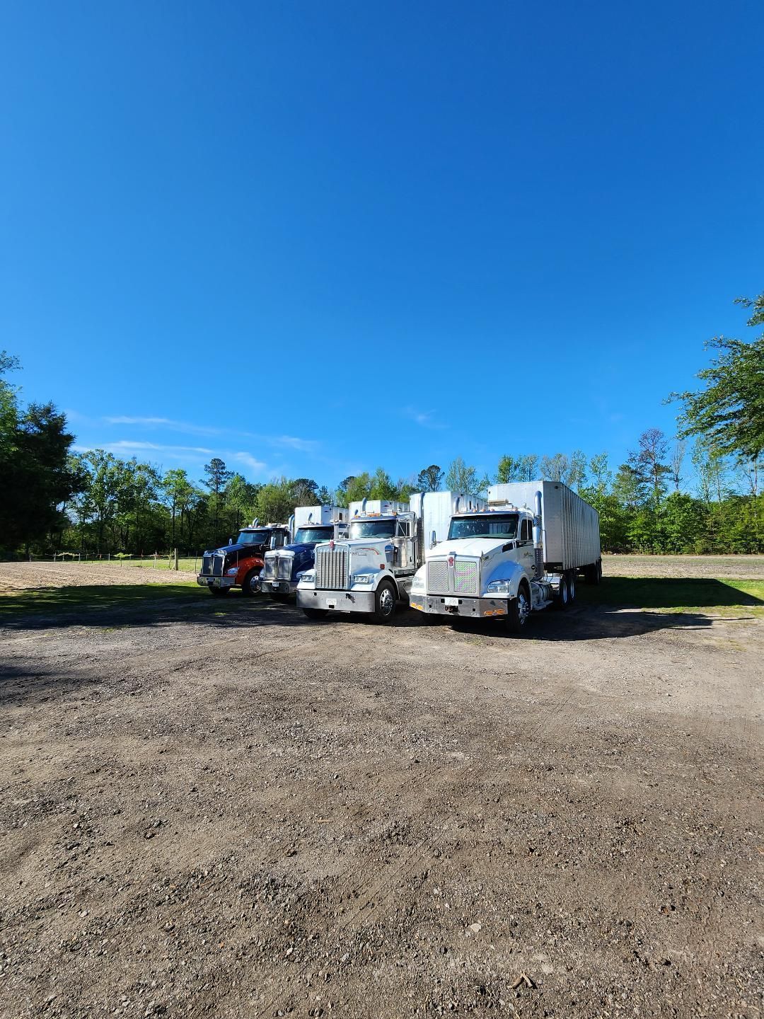 Three Semi-trucks Parked Side-by-side on a Gravel Lot — Valentine Detailing LLC in Walterboro, SC