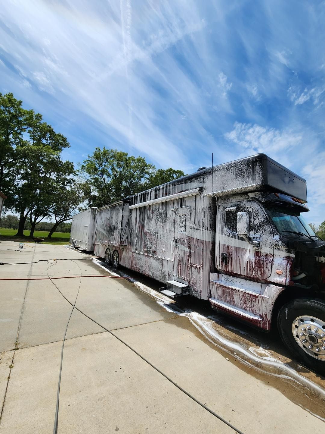 A Semi-truck Covered in Thick Cleaning Foam Parked on a Concrete Lot — Valentine Detailing LLC in Walterboro, SC