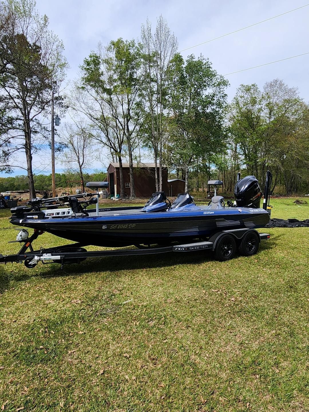 A Dark Blue Bass Boat on a Trailer Parked in a Grassy Field — Valentine Detailing LLC in Walterboro, SC