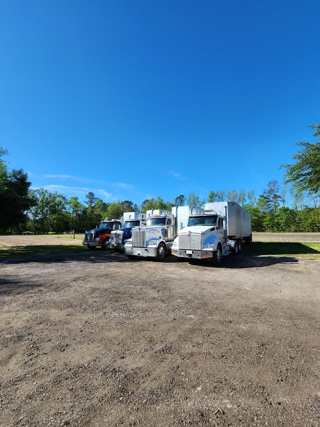 Four Semi-trucks Parked Side-by-side on a Gravel Lot — Valentine Detailing LLC in Walterboro, SC